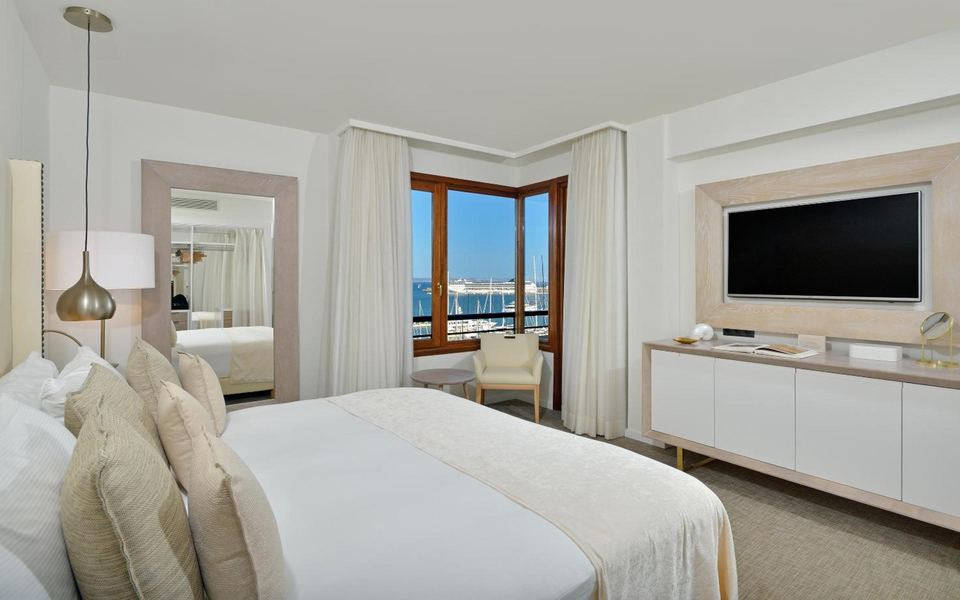 A hotel room with a double bed and a sea view